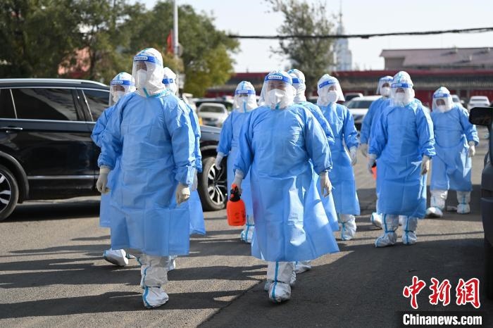 圖為醫(yī)務(wù)人員在封閉小區(qū)做防控工作?！⑽娜A 攝