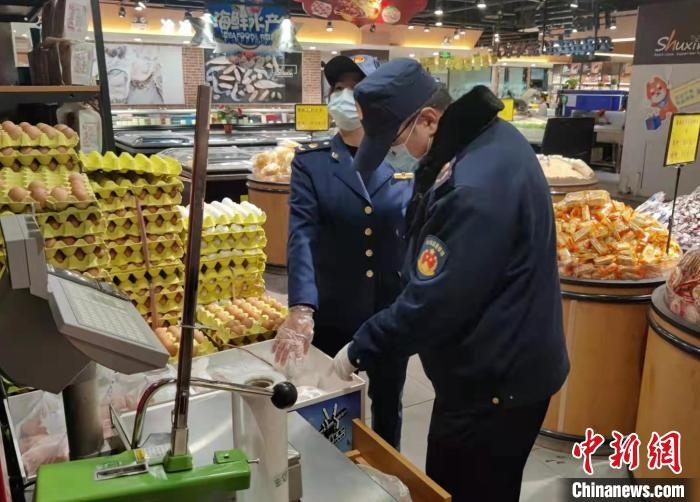 圖為疫情期間，甘肅嘉峪關(guān)市場(chǎng)監(jiān)管局工作人員檢查蔬菜市場(chǎng)?！?柴佳楠 　攝