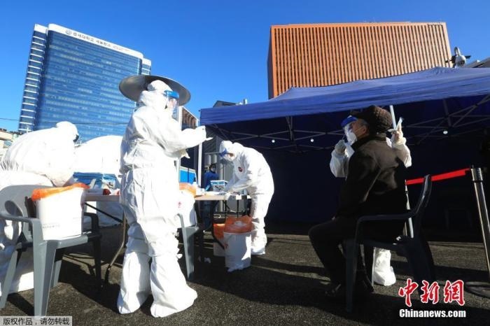 資料圖：韓國(guó)首爾，醫(yī)務(wù)人員對(duì)市民進(jìn)行新冠病毒檢測(cè)。