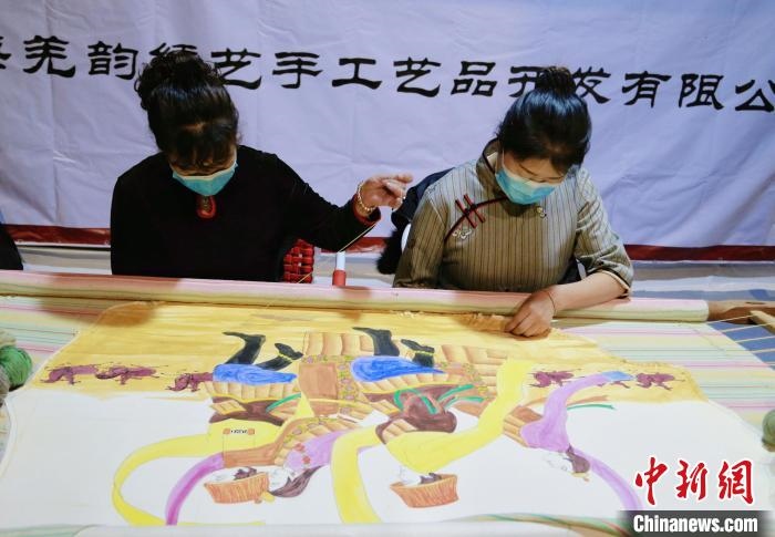 圖為皮繡藝人在市集上“秀”指尖技藝。　馬銘言 攝