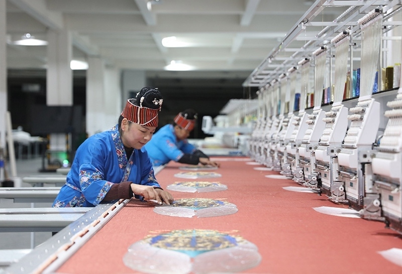 2023年2月13日，貴州省黔東南苗族侗族自治州施秉縣工業(yè)園區(qū)，工人在機(jī)繡車間作業(yè)。