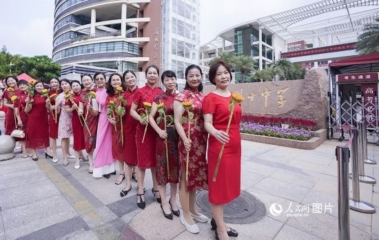 6月7日一早，廈門雙十中學(xué)考生家長們身穿旗袍，手拿向日葵在考場外為孩子加油打氣，寓意“旗開得勝，一舉奪魁”。人民網(wǎng)記者 陳博攝