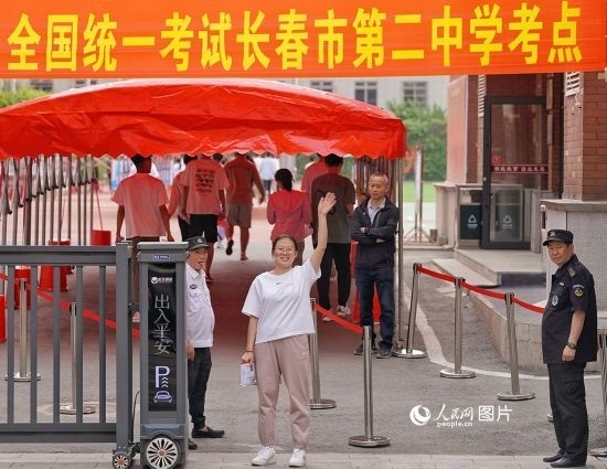 6月7日，在長春市第二中學(xué)考點，一名考生信心滿滿進入考場，并與家長揮手致意。人民網(wǎng)記者 李洋攝