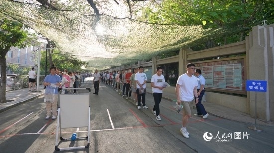 6月7日，烏魯木齊市第七十中學(xué)門口，考生們有序進入考場。人民網(wǎng) 李欣洋攝