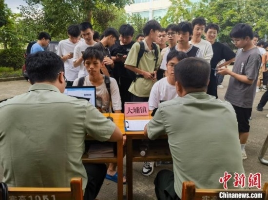 專武干部在發(fā)放兵役登記證。韋碩 攝