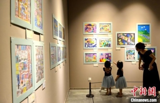 圖為家長帶著孩子參觀展覽。呂明 攝