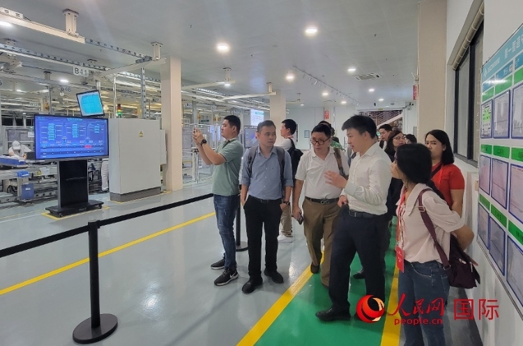 廣汽埃安工作人員向外媒記者進(jìn)行介紹。人民網(wǎng) 寧玉瑛攝