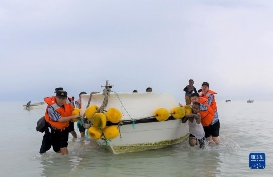7月21日，中國(guó)海軍“和平方舟”號(hào)醫(yī)院船醫(yī)護(hù)人員涉水登島，前往基里巴斯一診療點(diǎn)。新華社記者 黎云 攝
