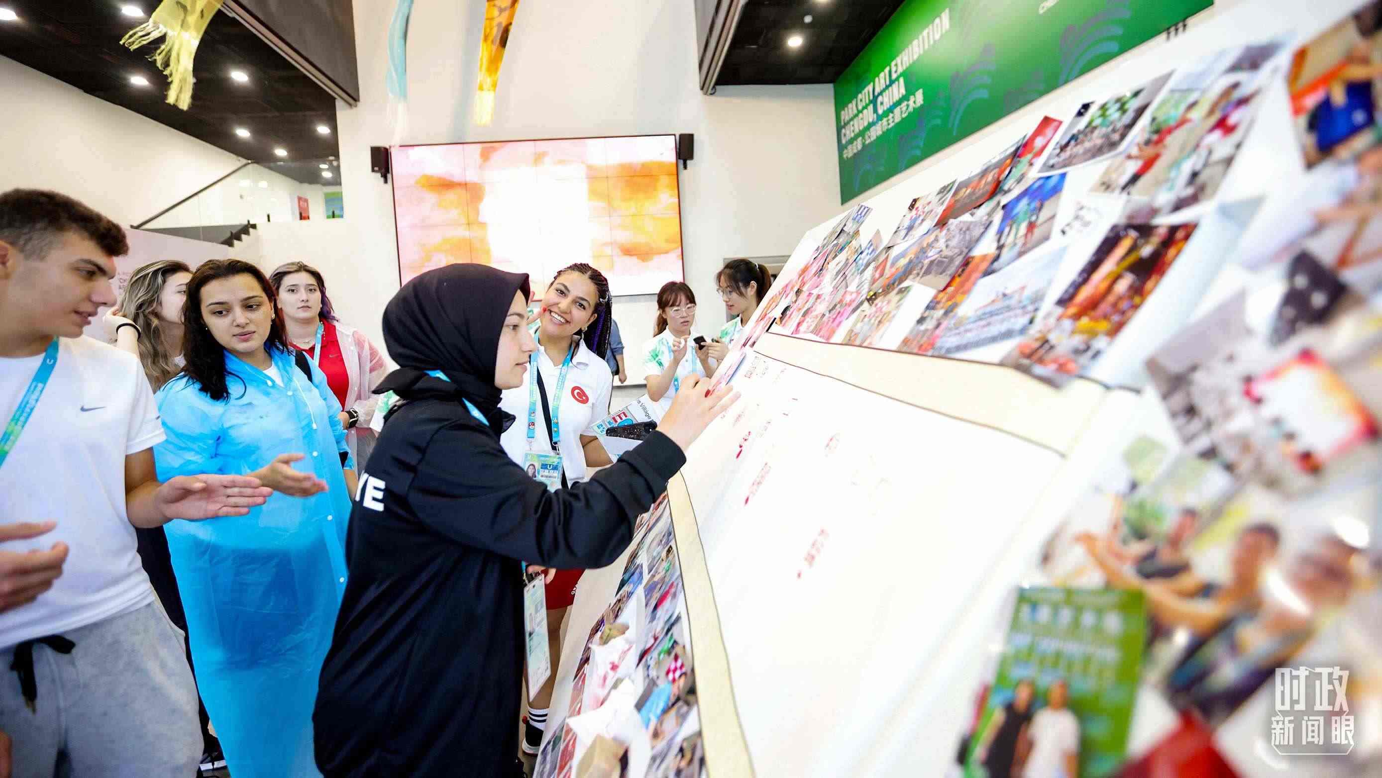 各國青年運(yùn)動員正在參觀成都大運(yùn)村內(nèi)的“雪山下的公園城市，煙火里的幸福成都”主題藝術(shù)展。（總臺央視記者魏幫軍拍攝）