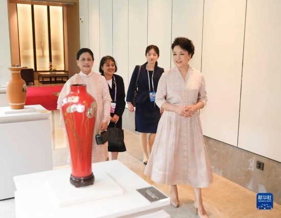 7月27日下午，國(guó)家主席習(xí)近平夫人彭麗媛在四川成都會(huì)見(jiàn)陪同印度尼西亞總統(tǒng)佐科來(lái)華出席第31屆世界大學(xué)生夏季運(yùn)動(dòng)會(huì)開(kāi)幕式并訪華的總統(tǒng)夫人伊莉亞娜。這是彭麗媛和伊莉亞娜欣賞成都特色非遺工藝品。新華社記者 丁林 攝