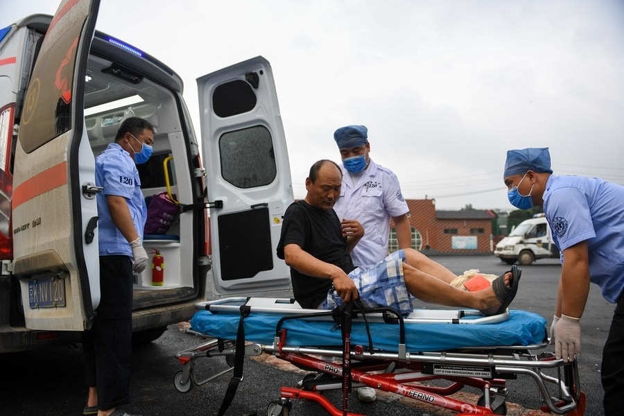 8月1日，在北京市門頭溝區(qū)妙峰山鎮(zhèn)妙峰山民族學(xué)校臨時安置點，北京急救中心工作人員在轉(zhuǎn)運一名受傷村民。新華社記者 鞠煥宗 攝