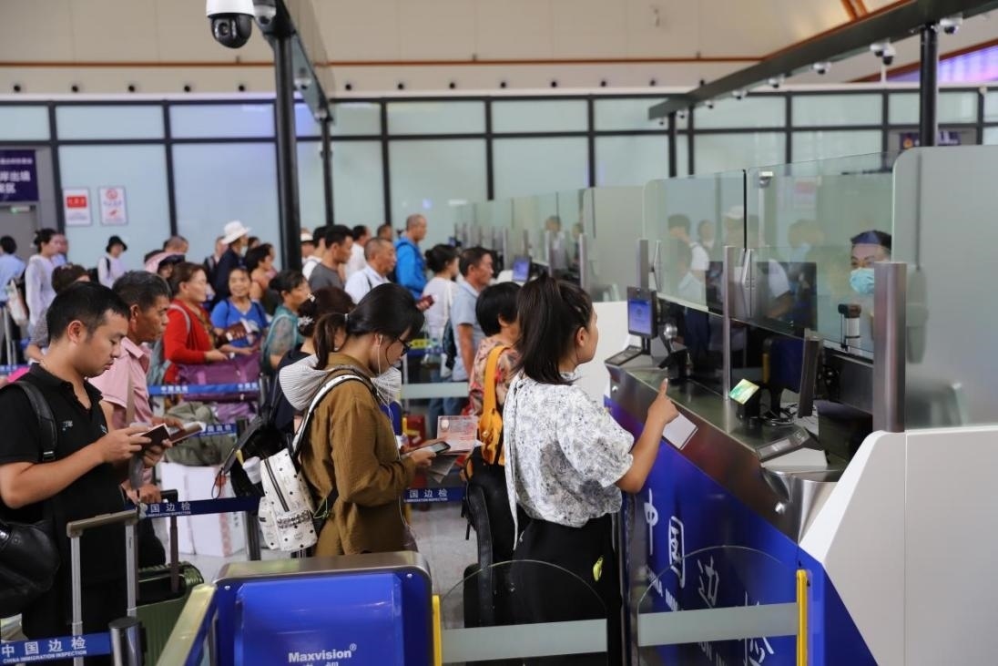出境旅客在辦理通關手續(xù)。人民網(wǎng)記者 李發(fā)興攝