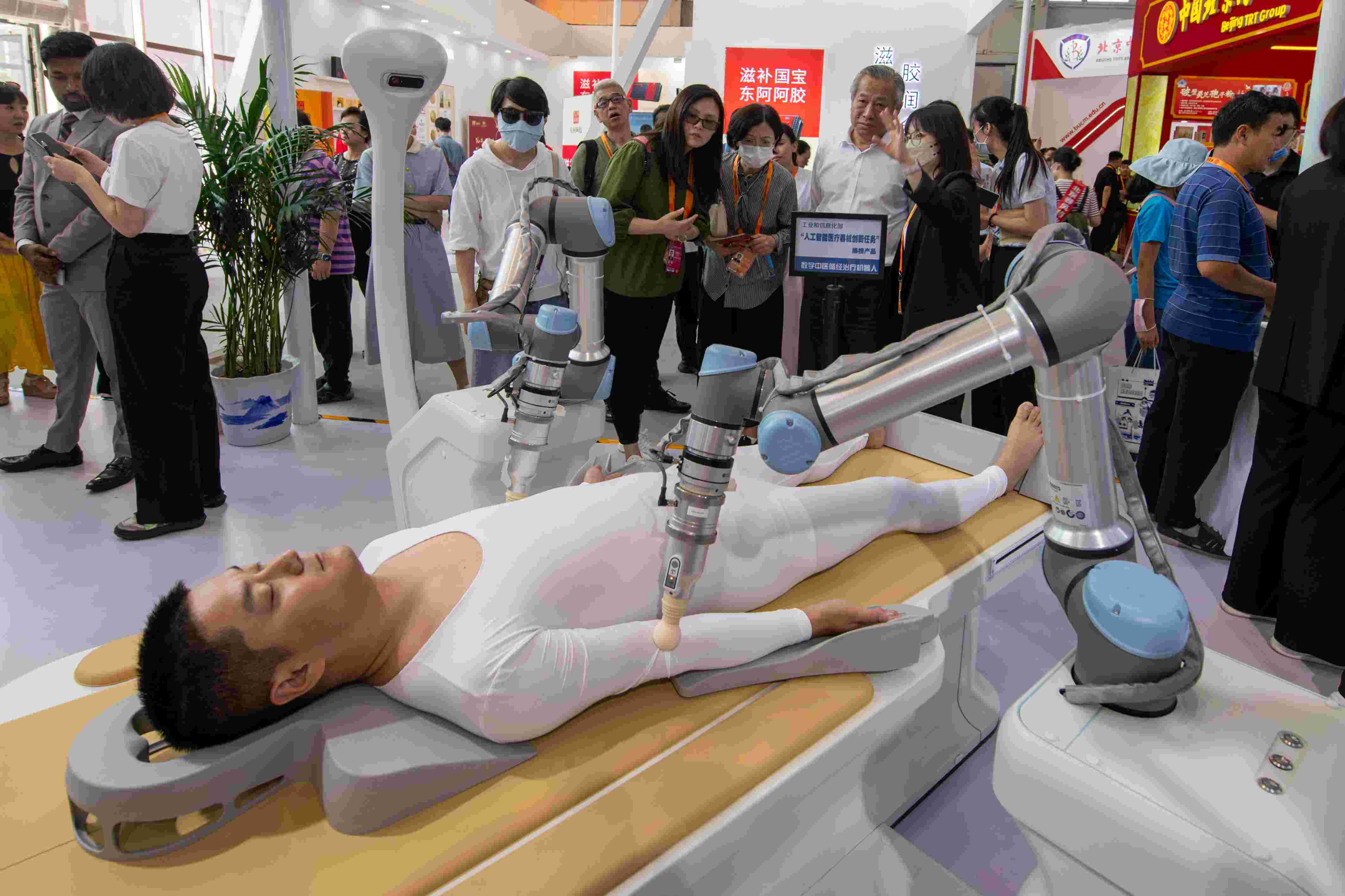 在位于首鋼園的健康衛(wèi)生服務(wù)展區(qū)，觀眾正在參觀數(shù)字中醫(yī)循經(jīng)治療機器人。人民網(wǎng)記者 翁奇羽攝
