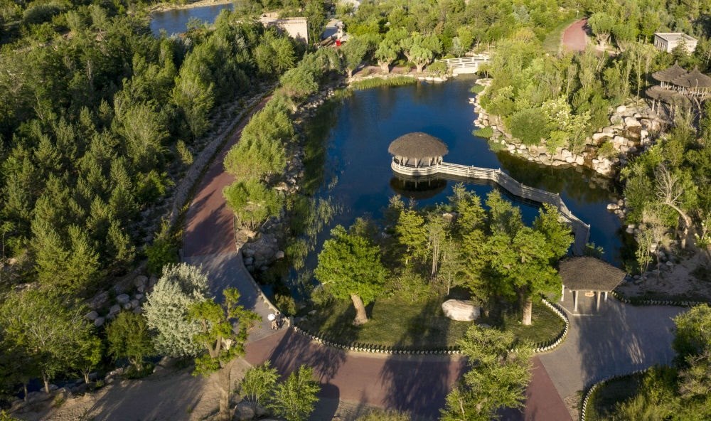 坐落在寧夏銀川市賀蘭山腳下的賀蘭山運(yùn)動休閑公園（2021年5月27日攝，無人機(jī)照片）。這里曾是一片砂石采礦塌陷區(qū)，當(dāng)?shù)赝ㄟ^植被景觀再造、水系建設(shè)、現(xiàn)代管網(wǎng)鋪建等手段，重新利用廢石、廢坑及各類廢棄建筑材料，把這里變成一座免費開放的主題公園。新華社記者 馮開華 攝