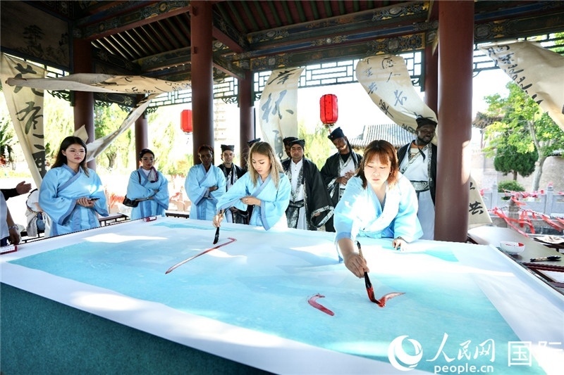 選手們提筆書寫“家園”二字。人民網(wǎng) 盧鵬宇攝