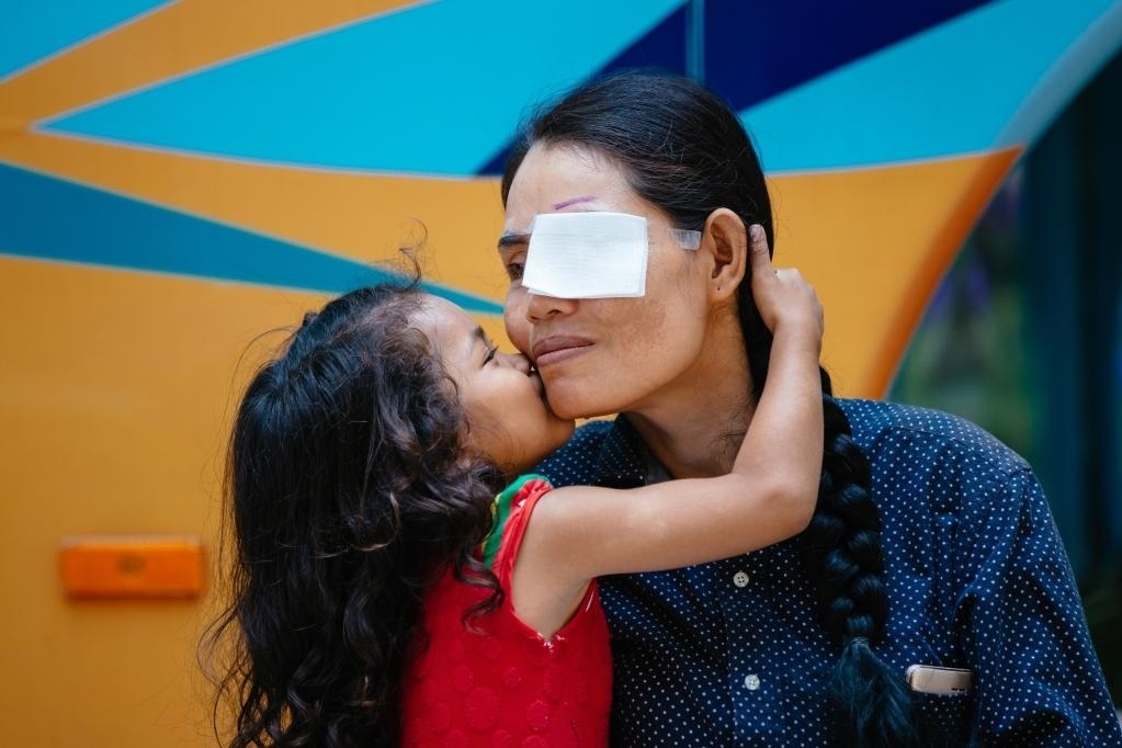 2019年3月15日，在柬埔寨磅湛省醫(yī)院，即將接受白內(nèi)障手術(shù)的患者孫美樂接受女兒的親吻祝福。在接受了中國醫(yī)療隊(duì)的白內(nèi)障義診手術(shù)后，她的視力逐步恢復(fù)，生活有了新的光明和希望。