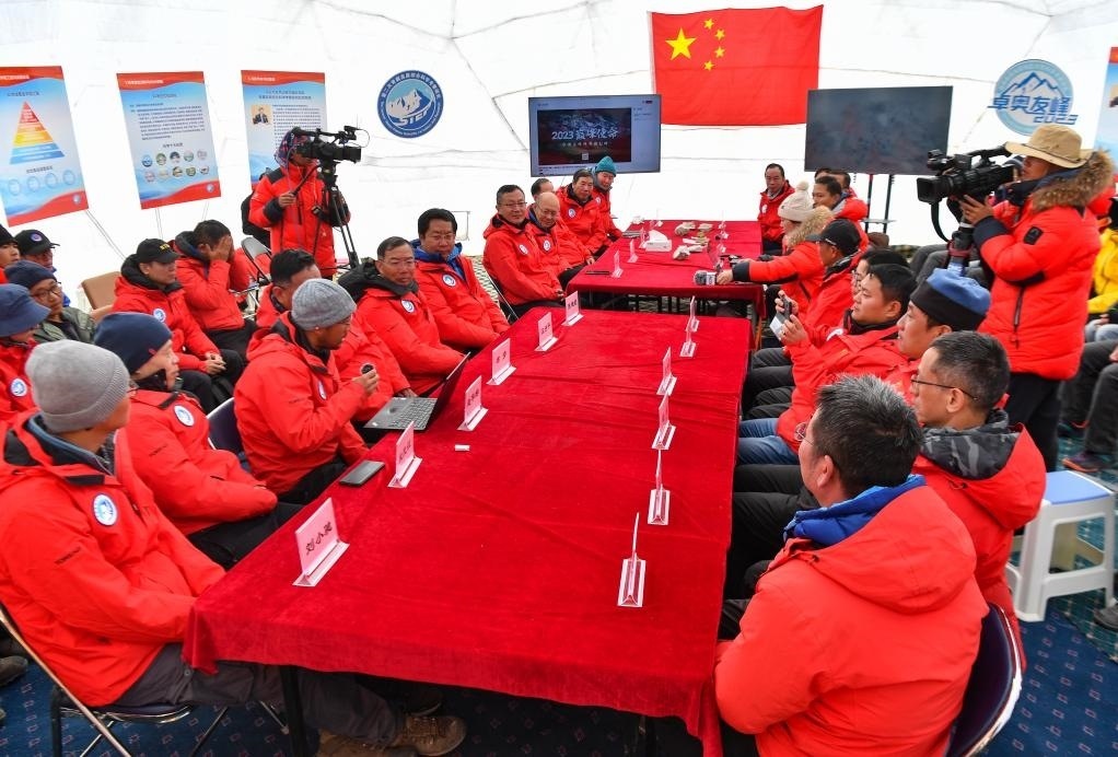 海拔4950米的卓奧友峰科考大本營，科考隊(duì)員趙華標(biāo)（手拿麥克風(fēng)看電腦者）在宣讀剛剛接收到的頂峰氣象觀測數(shù)據(jù)，這標(biāo)志著峰頂自動(dòng)氣象站架設(shè)成功，成功傳回觀測數(shù)據(jù)（10月1日攝）。新華社記者晉美多吉 攝