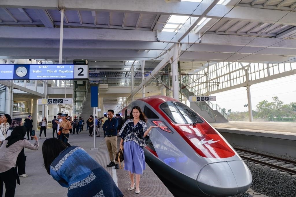 10月17日，在印度尼西亞萬(wàn)隆德卡魯爾站，乘客在站臺(tái)上和雅萬(wàn)高鐵高速動(dòng)車組列車合影。