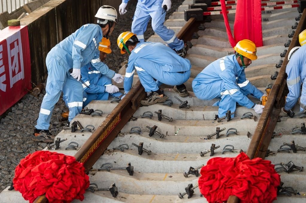 3月31日，在印度尼西亞雅加達(dá)雅萬(wàn)高鐵哈利姆車站，工人鋪設(shè)雅萬(wàn)高鐵全線最后一根鋼軌。