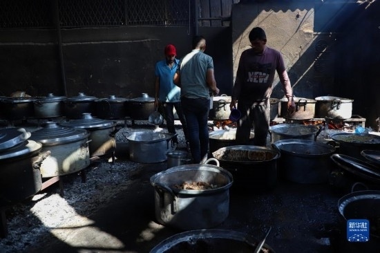 11月3日，在加沙地帶南部城市拉法，人們?cè)诿簹庵袛嗪笥貌窕鹱鲲?。新華社發(fā)（里澤克·阿卜杜勒賈瓦德攝）