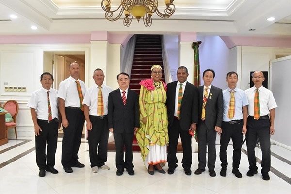 多米尼克總統(tǒng)伯頓和駐多米尼克大使林先江與中國農業(yè)技術專家組合影。中國駐多米尼克大使館供圖