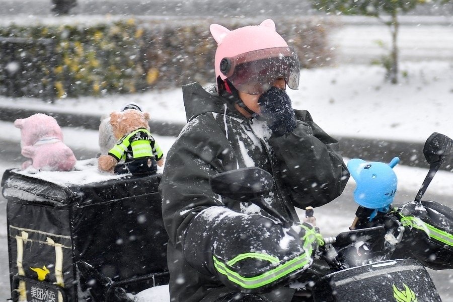 11月6日，在長春市街頭，一名外賣員在雪中騎行。新華社記者 許暢 攝