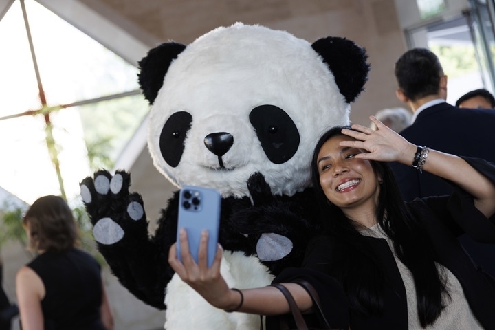 2022年8月24日，在美國華盛頓中國駐美國大使館，來賓與大熊貓玩偶合影。