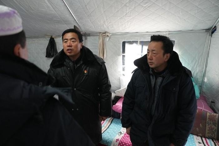 2023年12月22日，積石山縣大河家鎮(zhèn)大河村黨支部書(shū)記馬成忠（右二）在帳篷里和受災(zāi)群眾交流。新華社記者 陳斌 攝