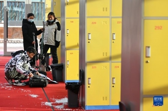 12月21日，游客在滑雪服務(wù)大廳整理滑雪裝備。