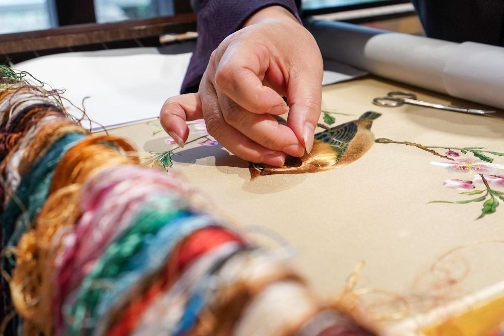 △2023年7月6日，盧建英在江蘇蘇州平江路的工作室內(nèi)刺繡。