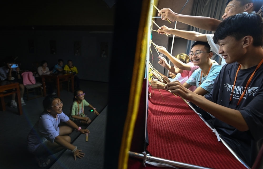 2023年8月8日，進行暑期研學的學生在位于陜西省西安市的中國秦腔藝術博物館體驗皮影戲演出。新華社記者 鄒競一 攝