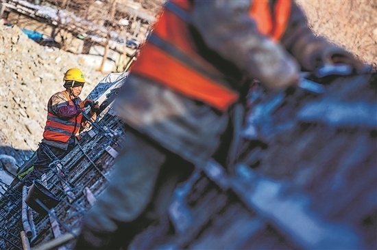 1月3日，房山區(qū)，工人正在雙泉河修筑堤壩。