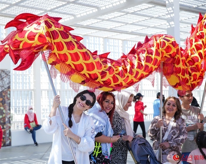 游客體驗舞龍。 人民網(wǎng) 塔里克·易卜拉欣攝