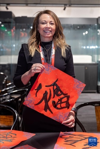 1月28日，在上海豫園舉行的民俗活動上，美國馬斯卡廷初中校長珍妮弗·李·弗里德利展示自己寫下的“?！弊?。 新華社記者 王翔 攝