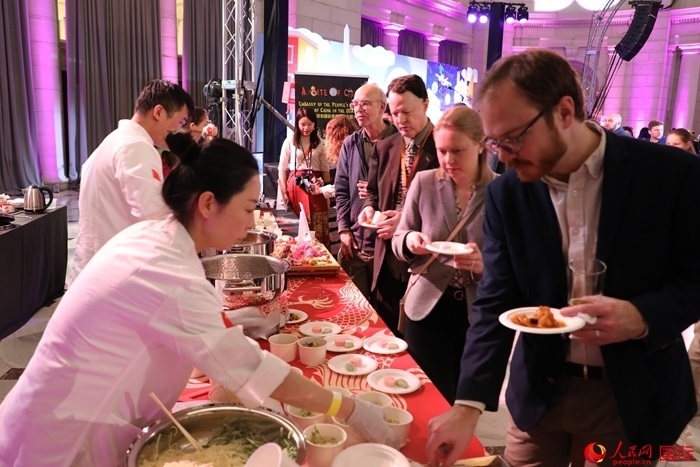 當(dāng)?shù)貢r(shí)間3月7日晚，華盛頓聯(lián)合車站廣場(chǎng)舉行駐美使團(tuán)“使館主廚挑戰(zhàn)賽”。圖為當(dāng)?shù)孛癖娫谥袊?guó)展臺(tái)前體驗(yàn)中國(guó)美食。人民網(wǎng)記者 李志偉攝