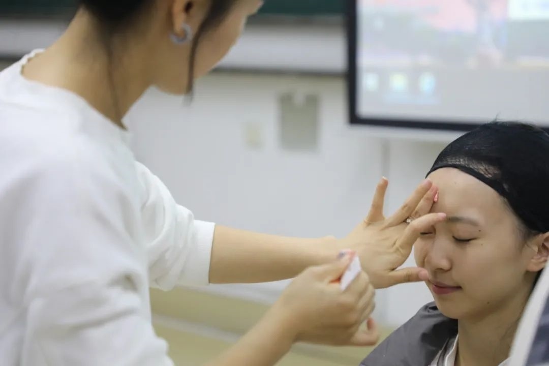 課堂上，一名學(xué)生在體驗(yàn)上戲妝。學(xué)校供圖