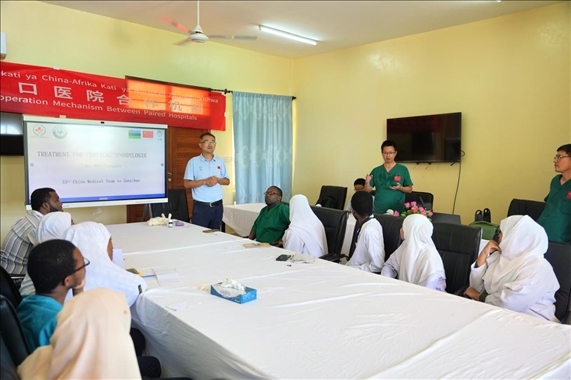 隊長蔣國慶和韋長群醫(yī)生一起解答問題。中國援桑醫(yī)療隊供圖