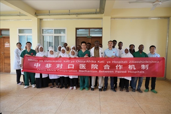 醫(yī)療隊隊員和當(dāng)?shù)蒯t(yī)生們合影。中國援桑醫(yī)療隊供圖