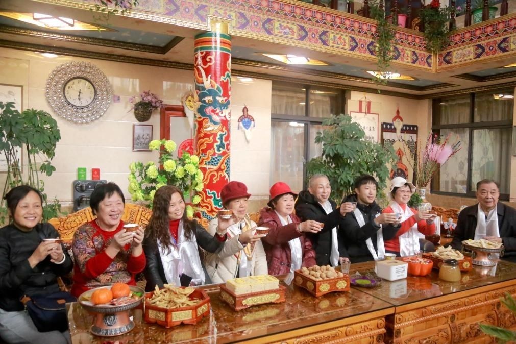 游客們?nèi)胱∶袼藓?，舉杯共飲酥油茶。新華社記者 邱星翔 攝