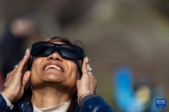 4月8日，一名女子在美國(guó)紐約州普拉茨堡觀看日食。新華社發(fā)（文森特·約翰遜攝）