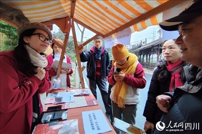 1月6日，“2024成都蒲江柑甜采摘節(jié)”上，記者見到了小萌（左一）和許多年輕人忙著做訪客接待、現(xiàn)場布置、票務(wù)核對、采摘服務(wù)等工作。人民網(wǎng)記者朱虹攝