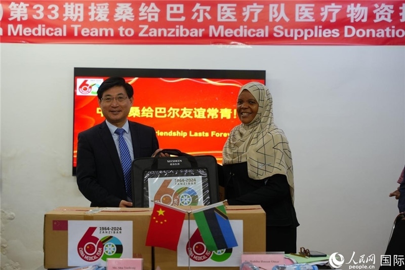 江蘇省蘇北人民醫(yī)院黨委書記束余聲捐贈物資與桑衛(wèi)生部首席秘書哈比巴。中國援桑醫(yī)療隊供圖