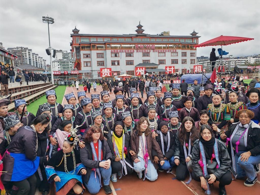 法國青年在“村超”賽場邊與參加表演的村民合影。新華社記者 羅羽 攝