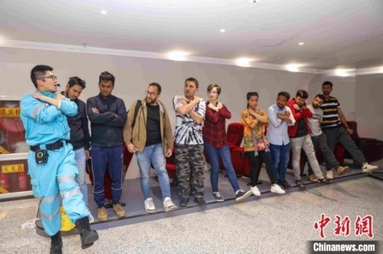 5月9日，工作人員指導(dǎo)留學(xué)生練習(xí)逃生技巧。張鷹 攝