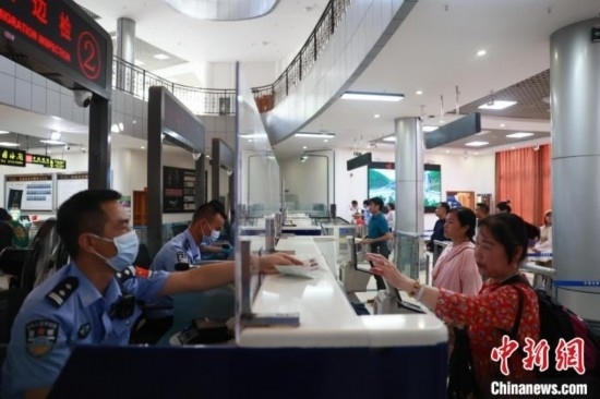 圖為旅客在磨憨口岸辦理通關(guān)手續(xù)。雷雨 攝