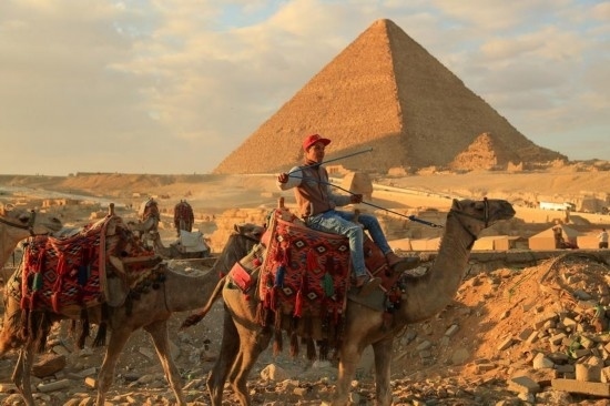 1月24日，商販騎駱駝離開埃及吉薩金字塔景區(qū)。新華社記者 隋先凱 攝