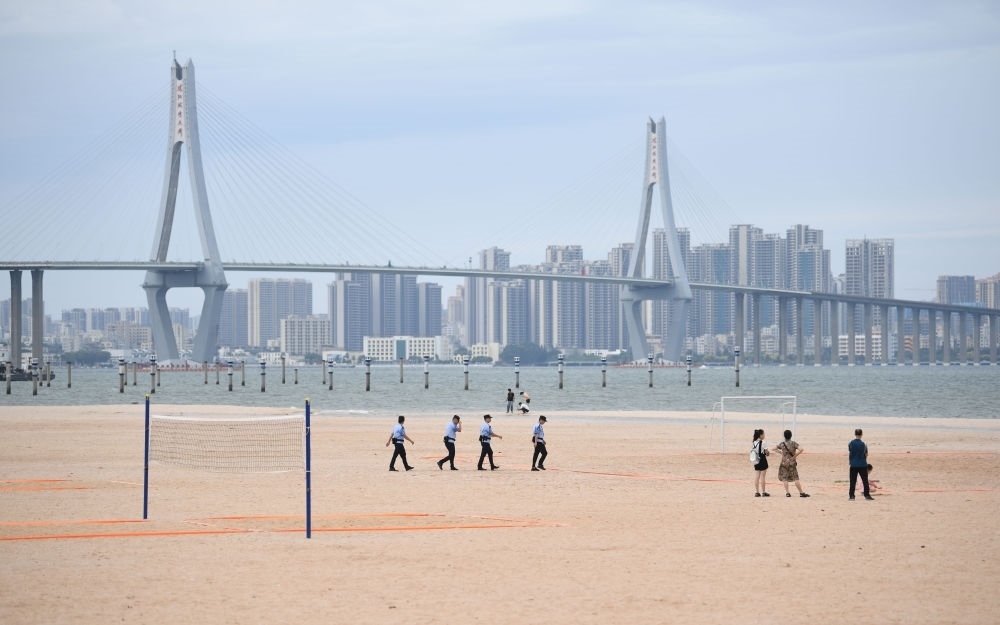 2023年7月17日，廣東湛江五環(huán)廣場(chǎng)的沙灘上，公安民警在執(zhí)勤巡邏。新華社記者 鄧華 攝