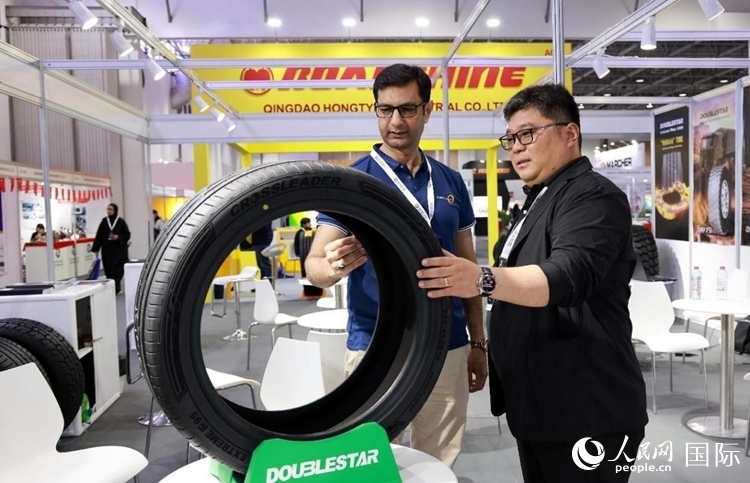 工作人員向客戶展示雙星電動汽車輪胎。和傳統(tǒng)汽車輪胎相比，電動汽車輪胎具有更高承載能力、更加靜音舒適、更好極速抓地、更低滾動阻力等特點。人民網(wǎng)記者 管克江攝