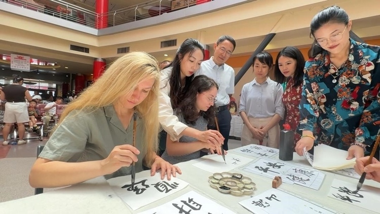羅馬尼亞友人在活動(dòng)現(xiàn)場(chǎng)學(xué)寫漢字。中國(guó)駐羅馬尼亞大使館領(lǐng)僑處供圖