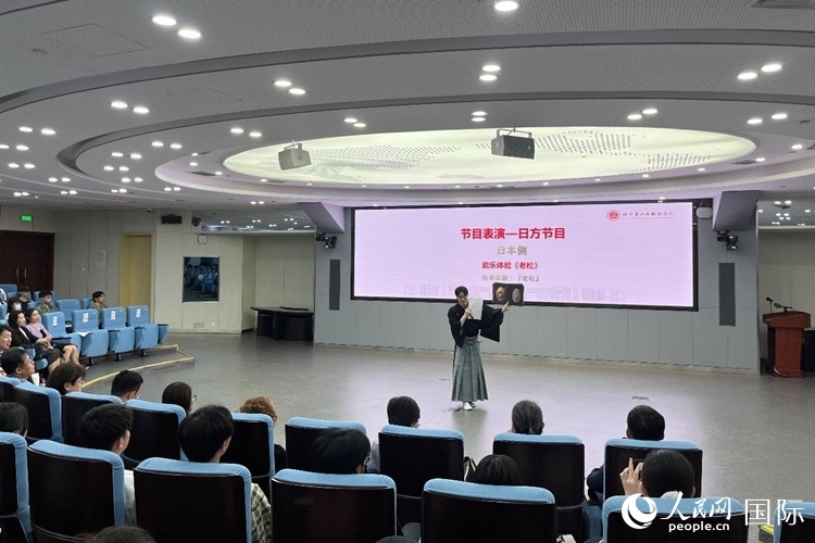 日本大學(xué)生介紹能樂知識(shí)。人民網(wǎng)記者 陳思攝